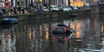 Toeristen redden vrouw uit zinkende auto in Amsterdamse gracht