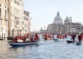 Kerstmannen varen in gondels op Canal Grande tijdens overstroming Venetië
