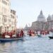 Kerstmannen varen in gondels op Canal Grande tijdens overstroming Venetië