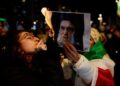 Demonstranten steken sigaretten aan met foto van Khamenei als daad van ongehoorzaamheid