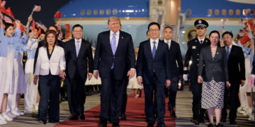 Trump begroet door jongeren met vlaggen bij aankomst in Peking